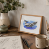 Happy Whale A5 desk mockup Framed Happy Whale print on an artist's desk with a sketchbook, eucalyptus, and paintbrushes